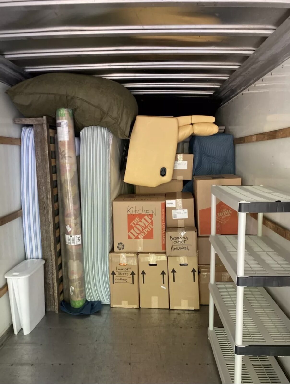 A neatly loaded moving truck with labeled boxes and padded furniture